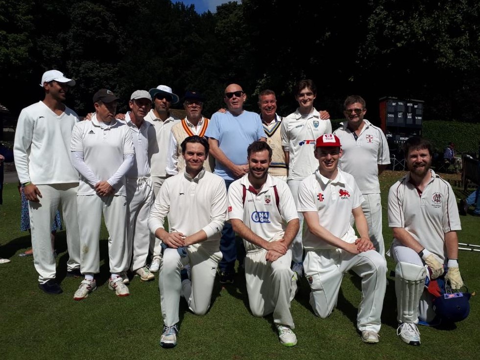 A group of men in white sports uniforms posing for a photo
Description automatically generated